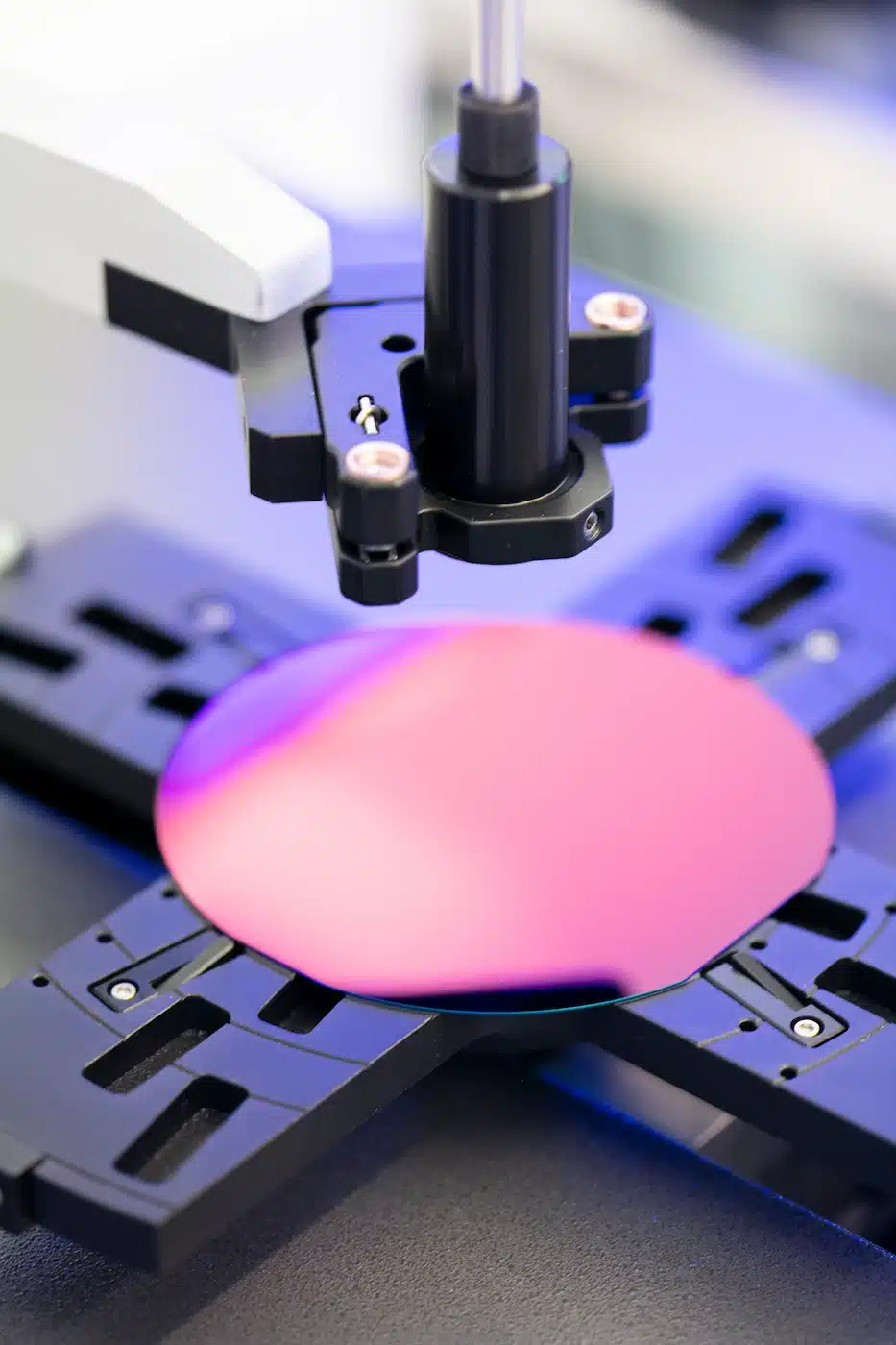 A pink disc is being placed on top of a lithography machine.