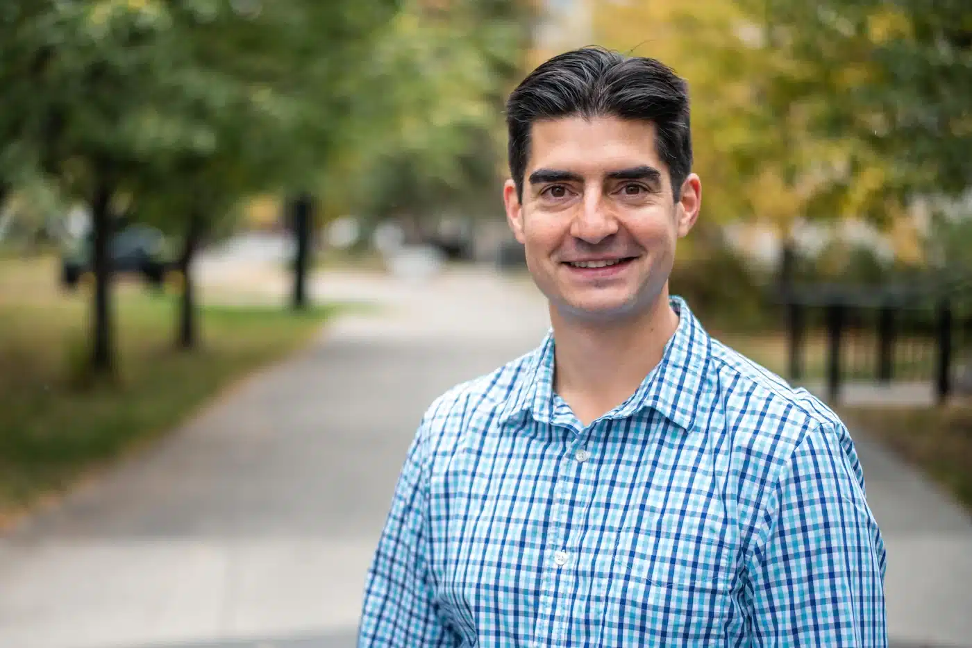 A man smiling in a park.